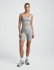 Woman wearing a gray athletic outfit on a white background.