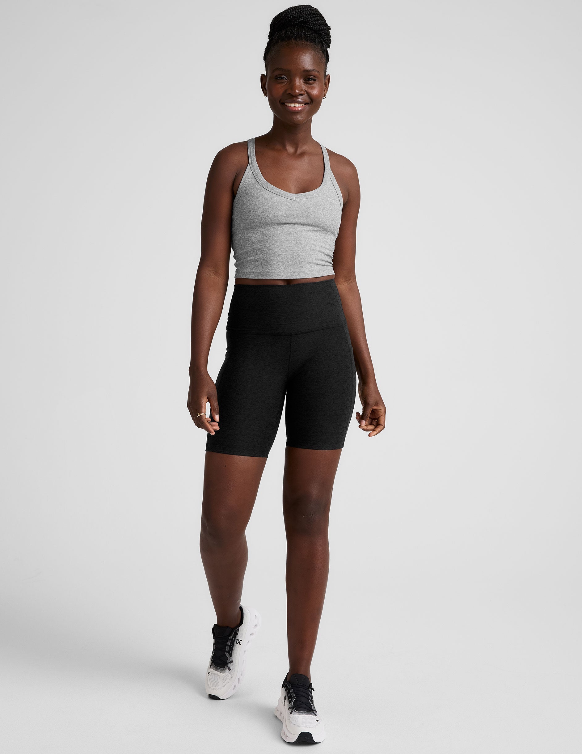model wearing black 7" inseam biker shorts with pockets on a plain background. 