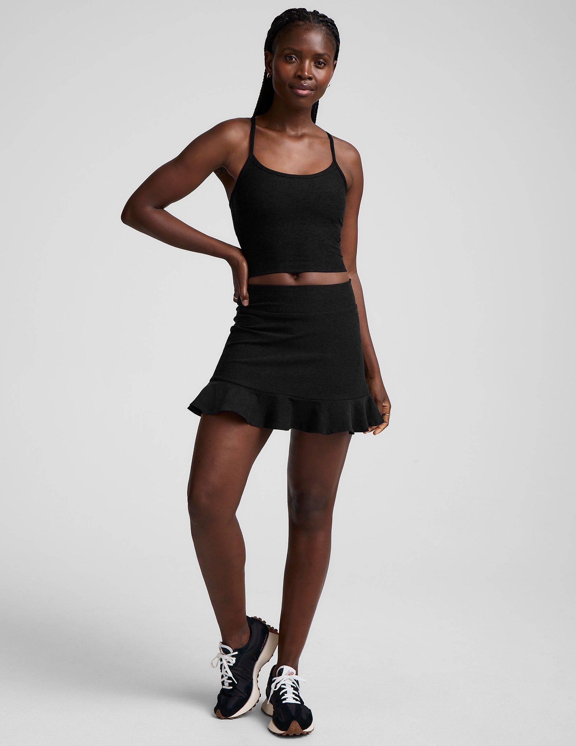 black high-waisted skirt with a ruffle hem and built-in shorts with pockets.