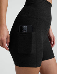 woman wearing black pocket biker shorts shorts on a plain background.