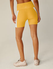 yellow high-waisted spacedye biker shorts with white lining down the sides.