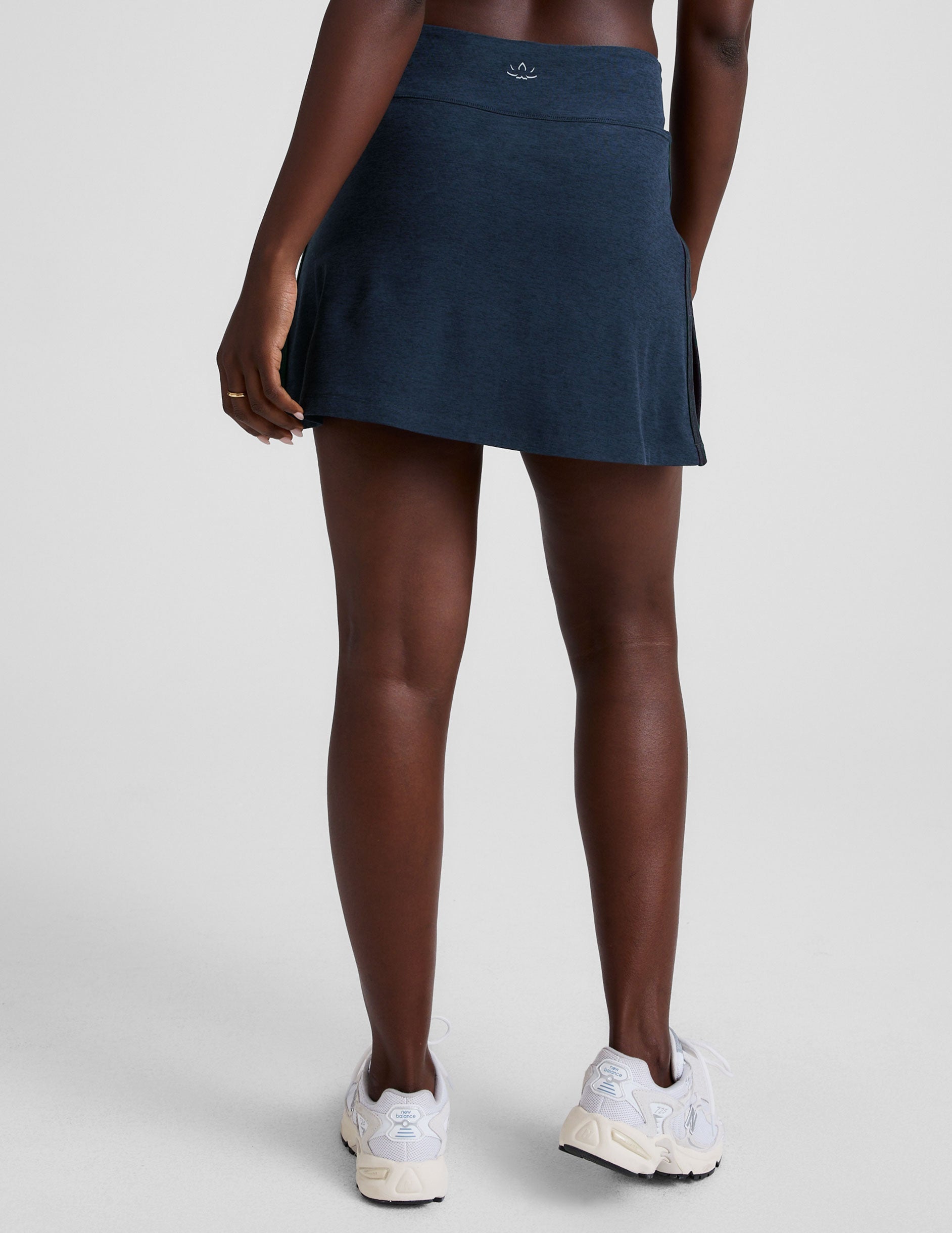 blue mid-rise skirt with white piping on sides, side slits, and built-in shorts with pockets. 