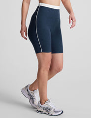 navy blue high-waisted biker shorts with a 5" inseam, waistband colorblock panels​, and contrast piping detail on leg​. 