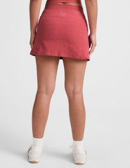 red high-waisted mini athletic skirt with a drawstring at waistband and built-in shorts with pockets.