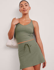 green mini skirt with a drawstring at waistband and pockets.