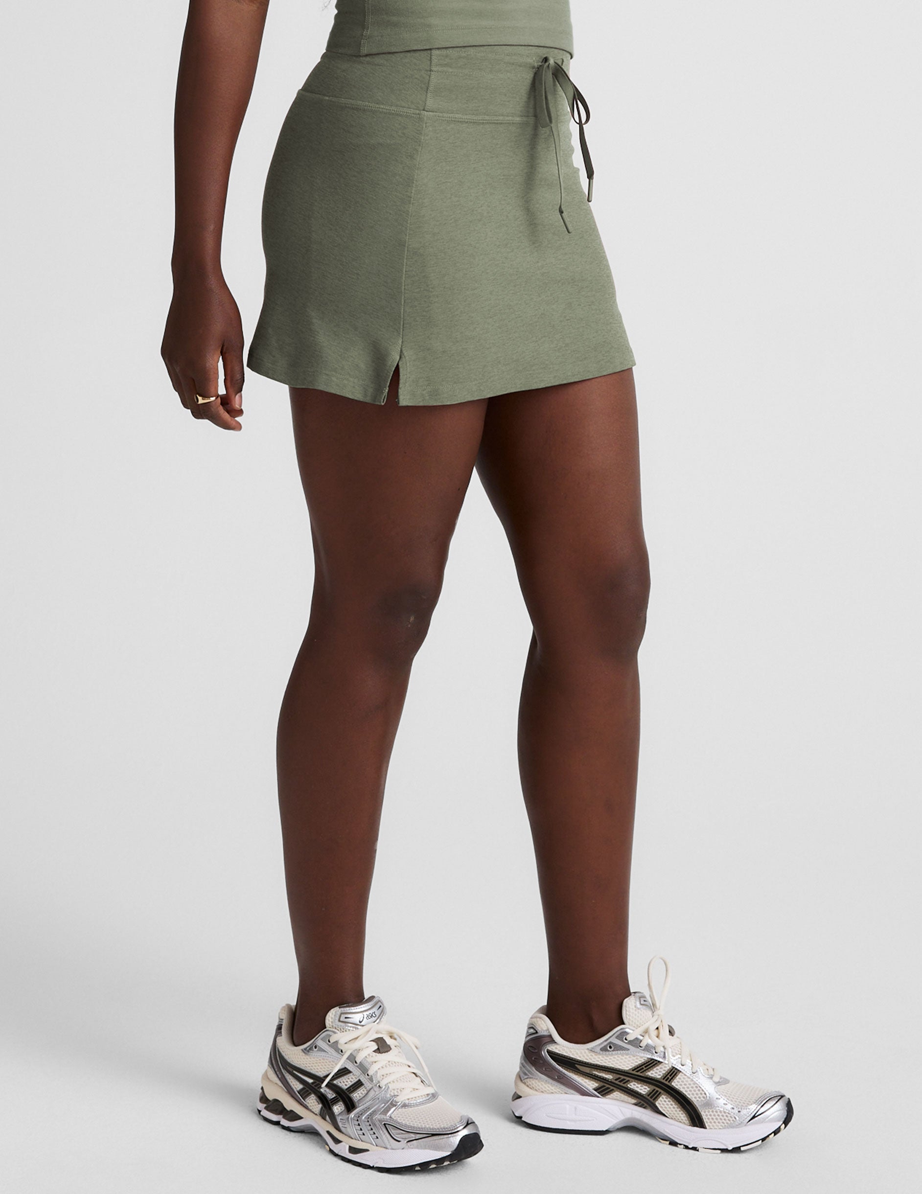 green mini skirt with a drawstring at waistband and pockets.