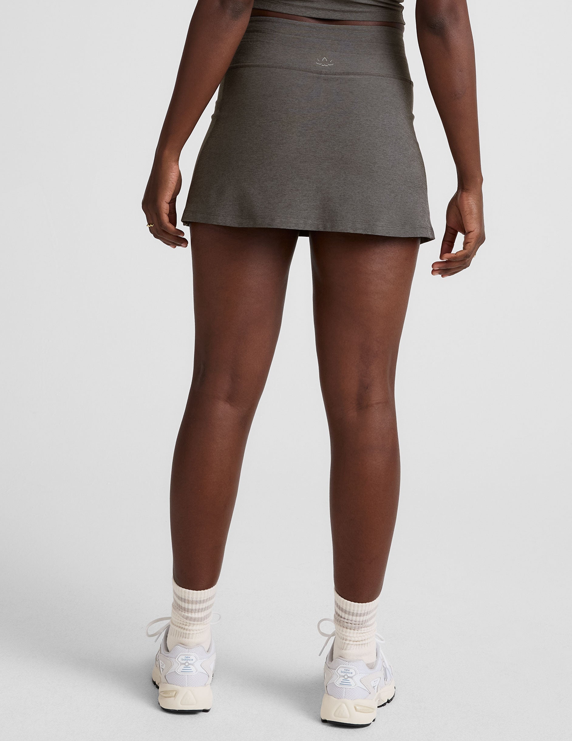 grey high-waisted mini athletic skirt with a drawstring at waistband and built-in shorts with pockets.