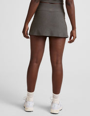 grey high-waisted mini athletic skirt with a drawstring at waistband and built-in shorts with pockets.