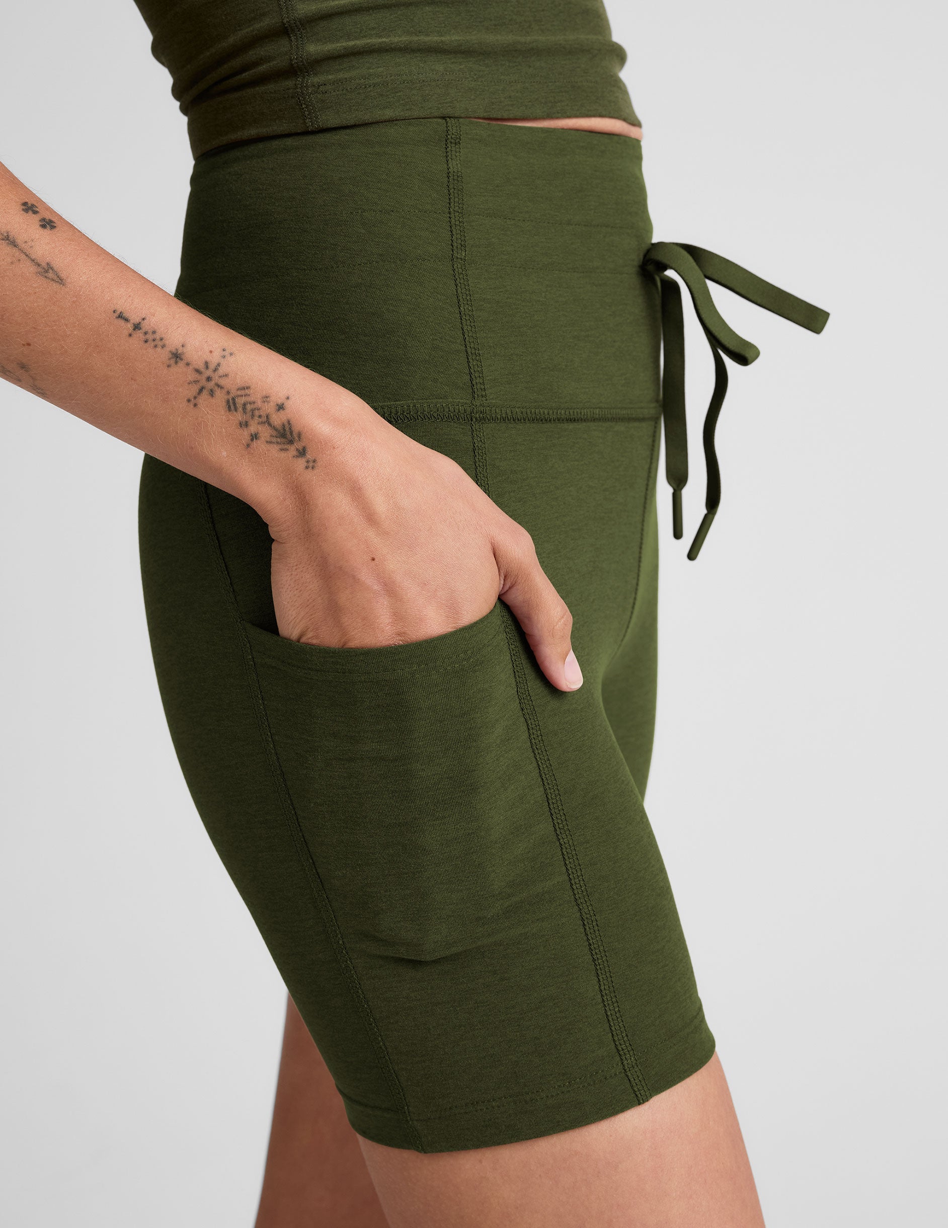 green 5" inseam biker shorts with pockets and a drawcord at waistband. 
