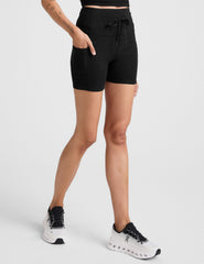 black high-waisted 5" inseam biker shorts with pockets and a drawstring at waistband. 