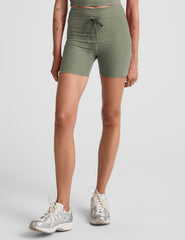green high-waisted 5" inseam biker shorts with pockets and a drawstring at waistband. 