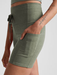 green high-waisted 5" inseam biker shorts with pockets and a drawstring at waistband. 