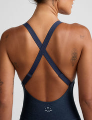 blue midi length jumpsuit with cross straps on back.