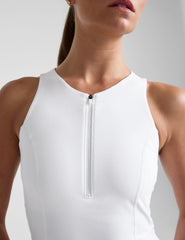 close-up image of a white mini tank dress with a racerback detail and a half zipper on front neckline.