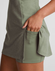 green mini active dress with a zipper on the front neckline and a side slit.