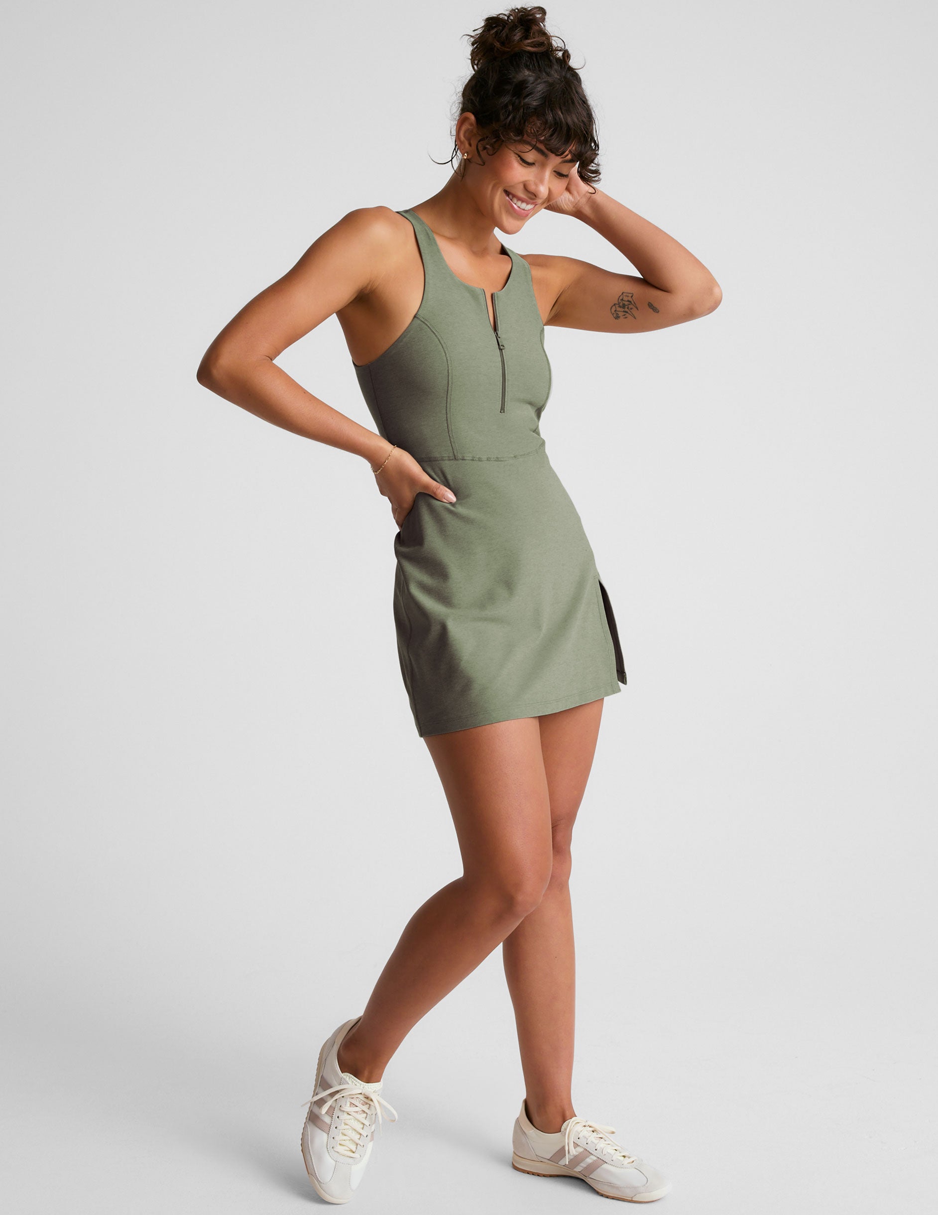 green mini active dress with a zipper on the front neckline and a side slit.