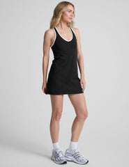 black mini length dress with a front V neckline​, back keyhole detail​, contrast binding at neckline and arm openings, and an Interior bodysuit with pockets​. 