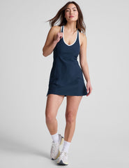 navy blue mini length dress with a front V neckline​, back keyhole detail​, contrast binding at neckline and arm openings, and an Interior bodysuit with pockets​. 