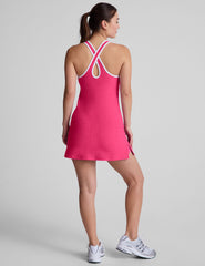 pink mini dress with a v-neckline, crossover strap detail in the back, and built-in shorts with pockets. 