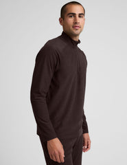 model wearing a brown men's quarter-zip pullover against a plain background.