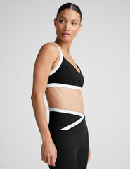 black v-neck racerback bra top with princess seams and white contrast lining.