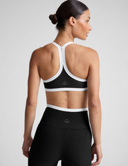 black v-neck racerback bra top with princess seams and white contrast lining.