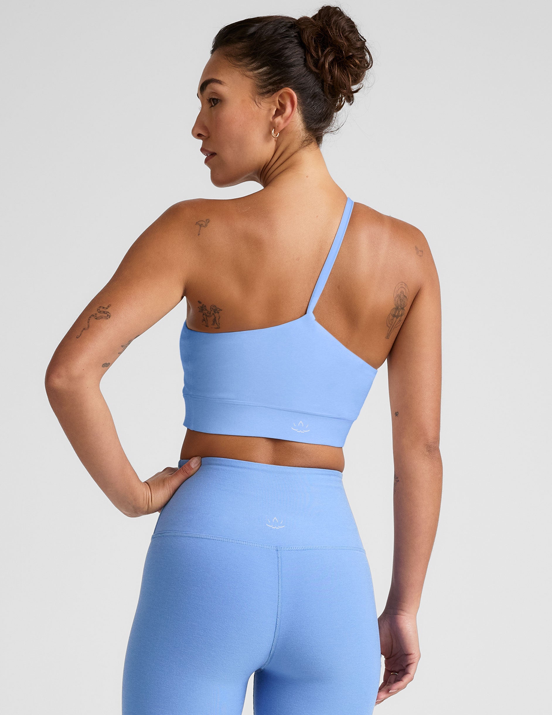 blue long line length bra with a one strap detail and an open back.