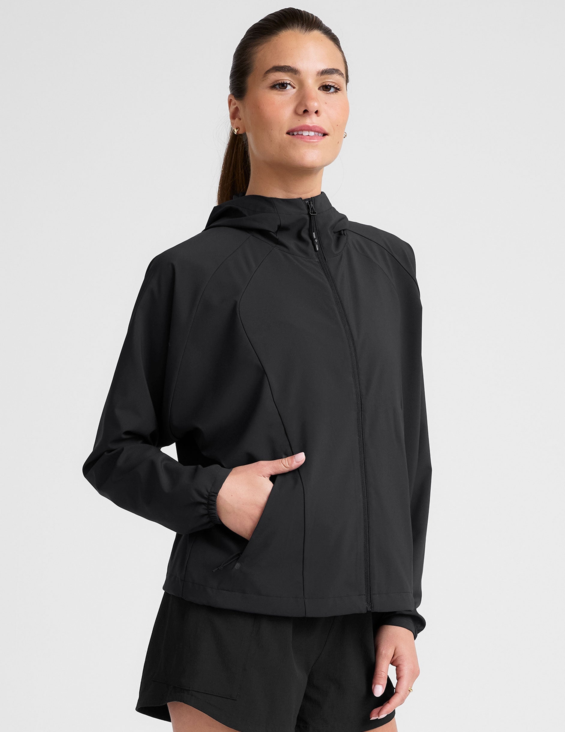 model wearing a black jacket and shorts on a light gray background.