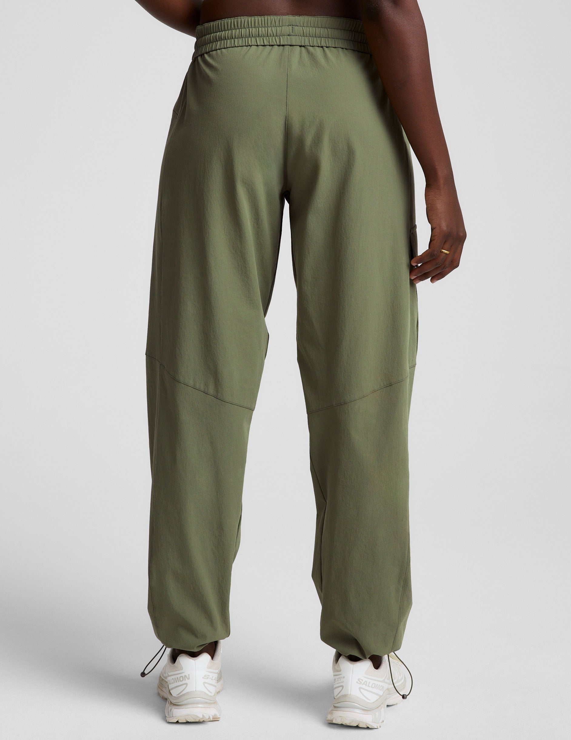 model wearing olive green cargo pants on a white background.