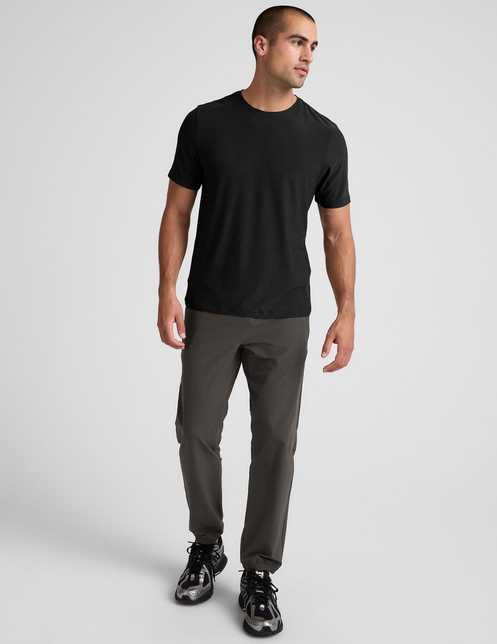 dark gray joggers and a grey t-shirt on a plain background.