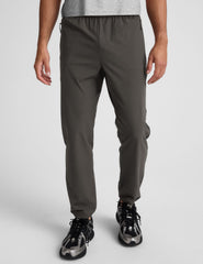 dark gray joggers and a grey t-shirt on a plain background.