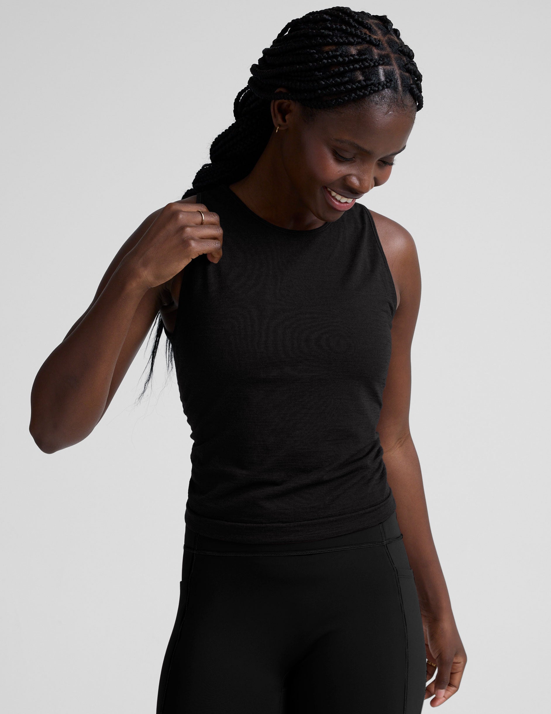 model wearing a scoop high neck racerback tank top against a plain background.