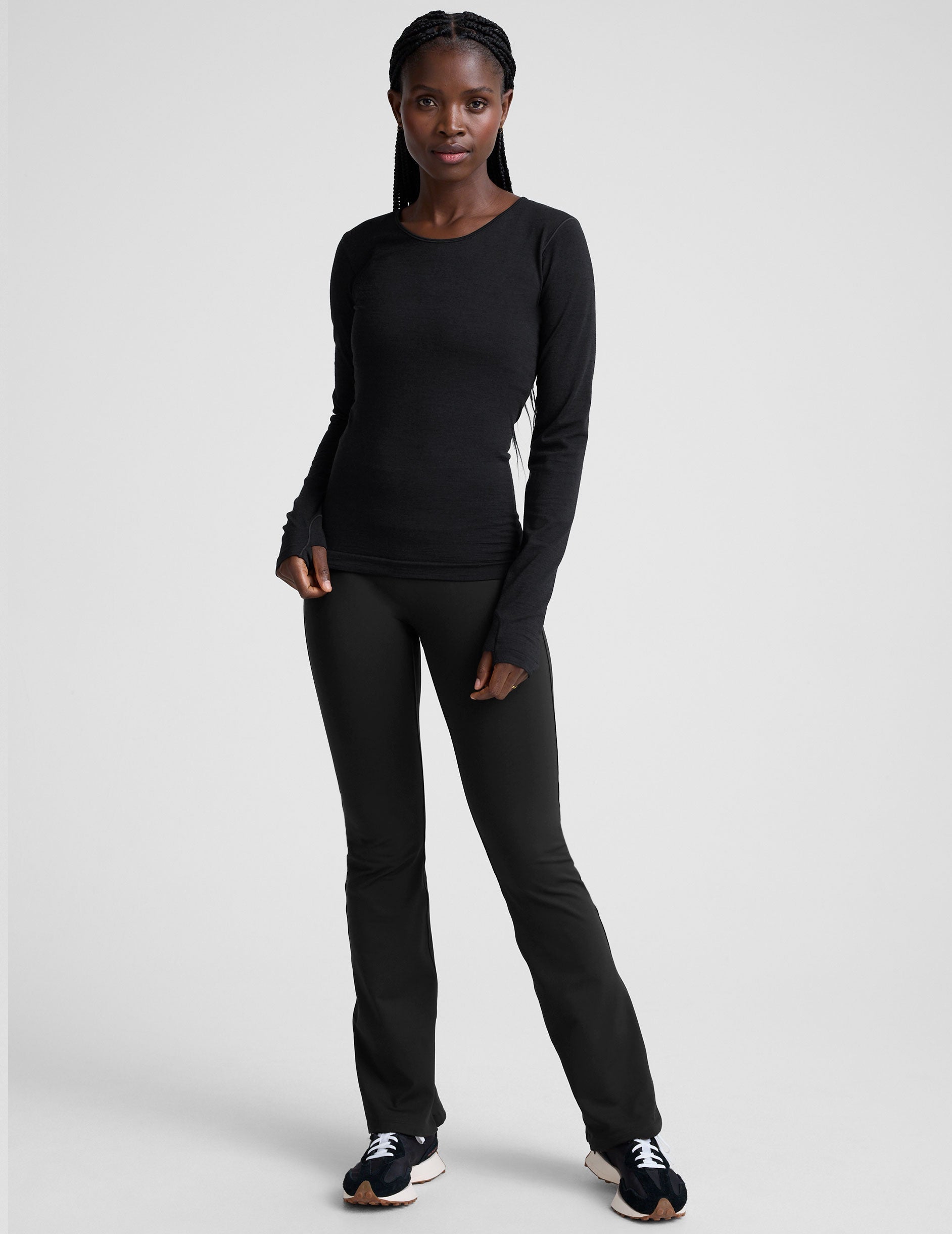 model wearing a black long sleeve crewneck top against a plain background.