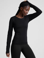 model wearing a black long sleeve crewneck top against a plain background.