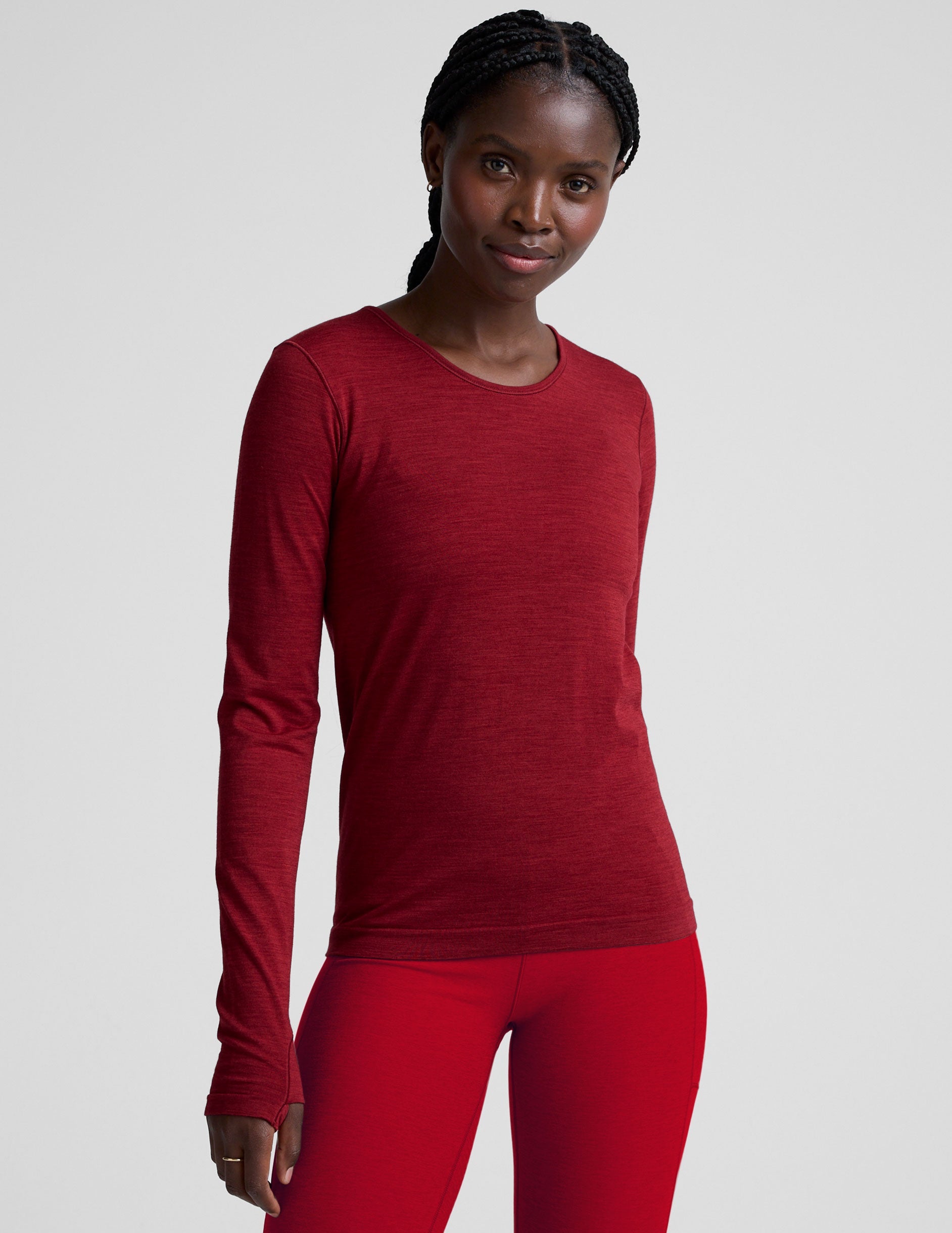 woman wearing a red long-sleeve top and red leggings on a plain background.