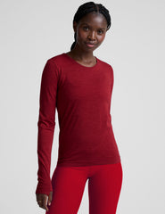 woman wearing a red long-sleeve top and red leggings on a plain background.