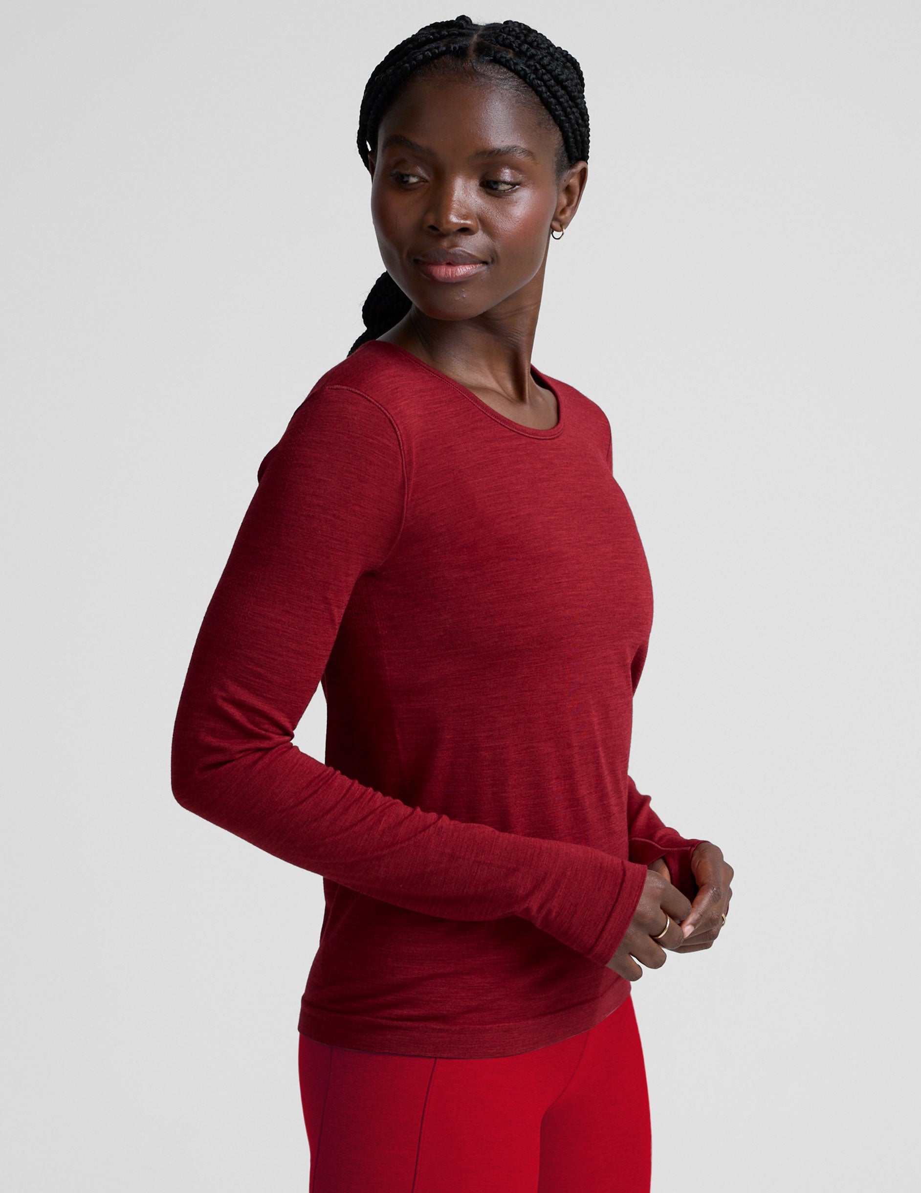 woman wearing a red long-sleeve top and red leggings on a plain background.