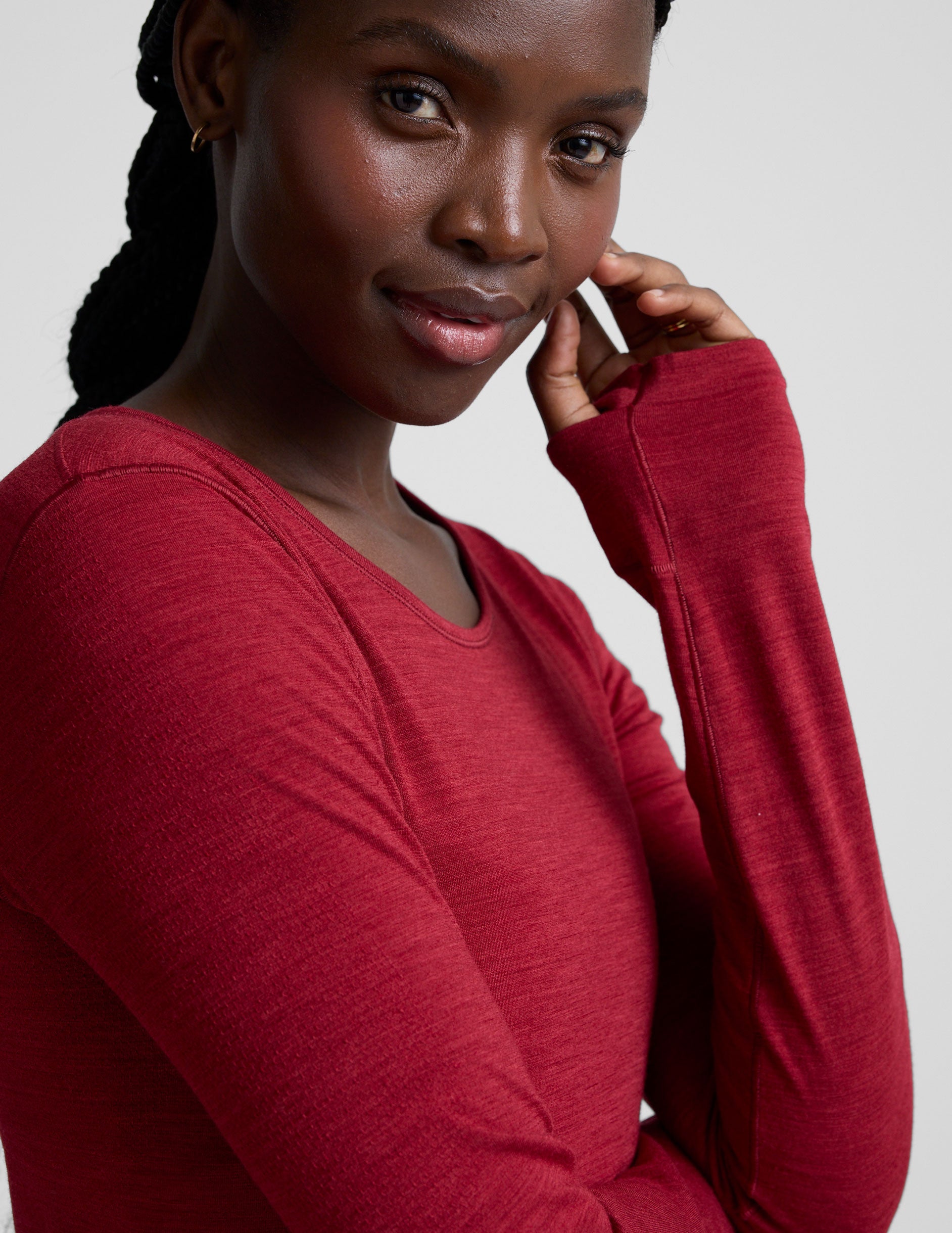 woman wearing a red long-sleeve top and red leggings on a plain background.